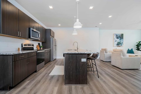 A modern kitchen with dark wood cabinets and a white countertop.