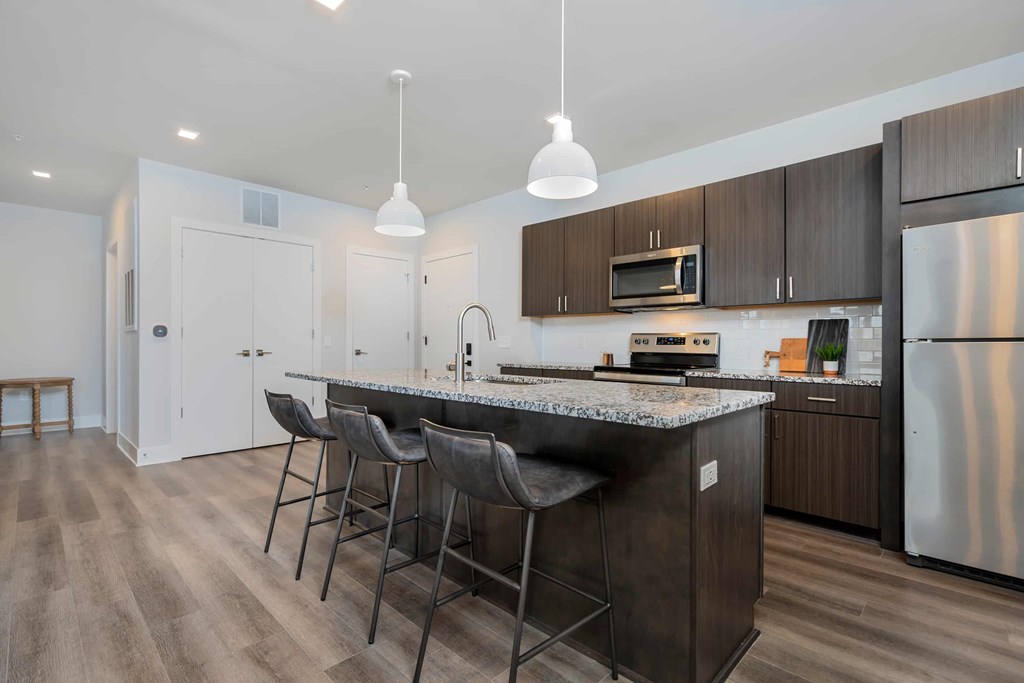 A kitchen with a granite countertop and stainless steel appliances.