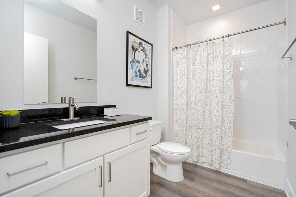A bathroom with a toilet, sink, and shower.
