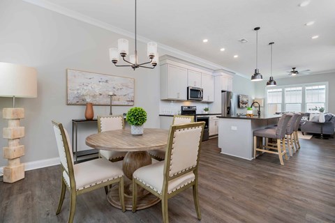A modern dining room with a round table and chairs.