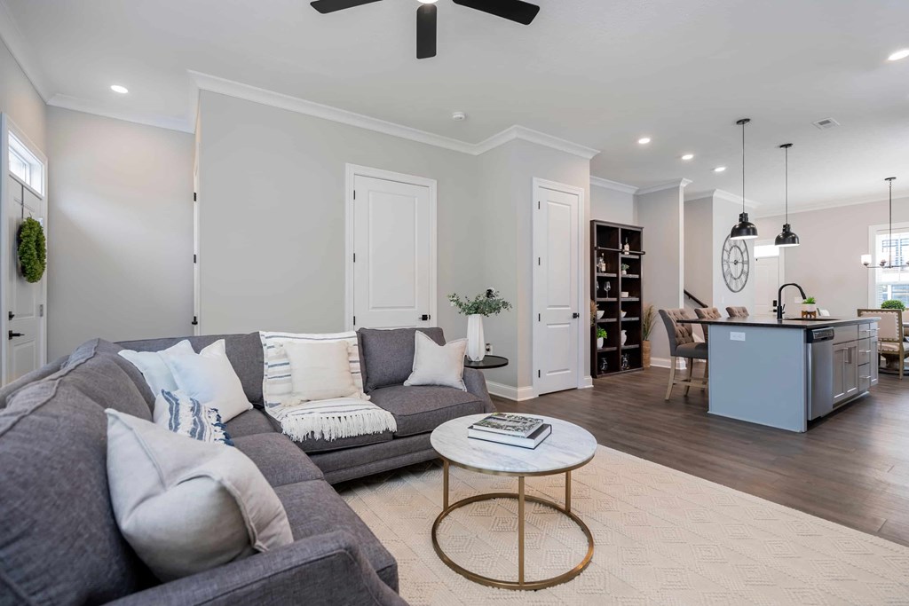 A living room with a grey couch and a round coffee table.