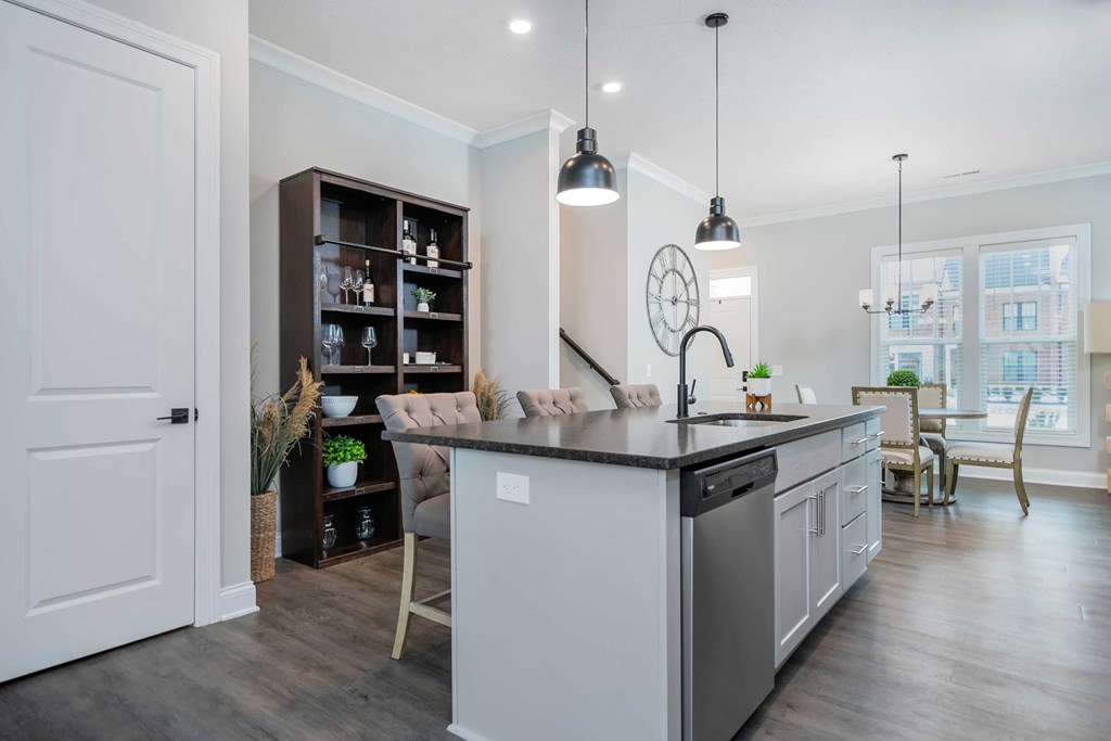 A modern kitchen with a large island and a dining area.