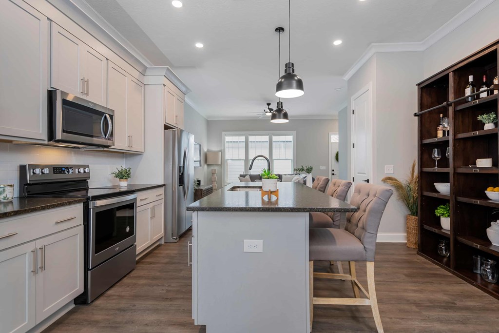 A modern kitchen with a center island and a dining area.