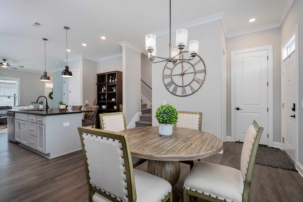 A dining room with a round table and chairs.
