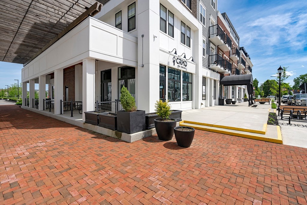 A white building with a black awning and a sign that says