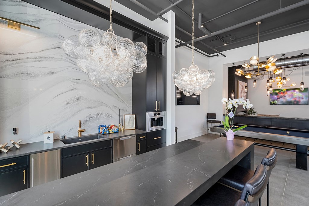 A modern kitchen with a marble backsplash and a pool table.