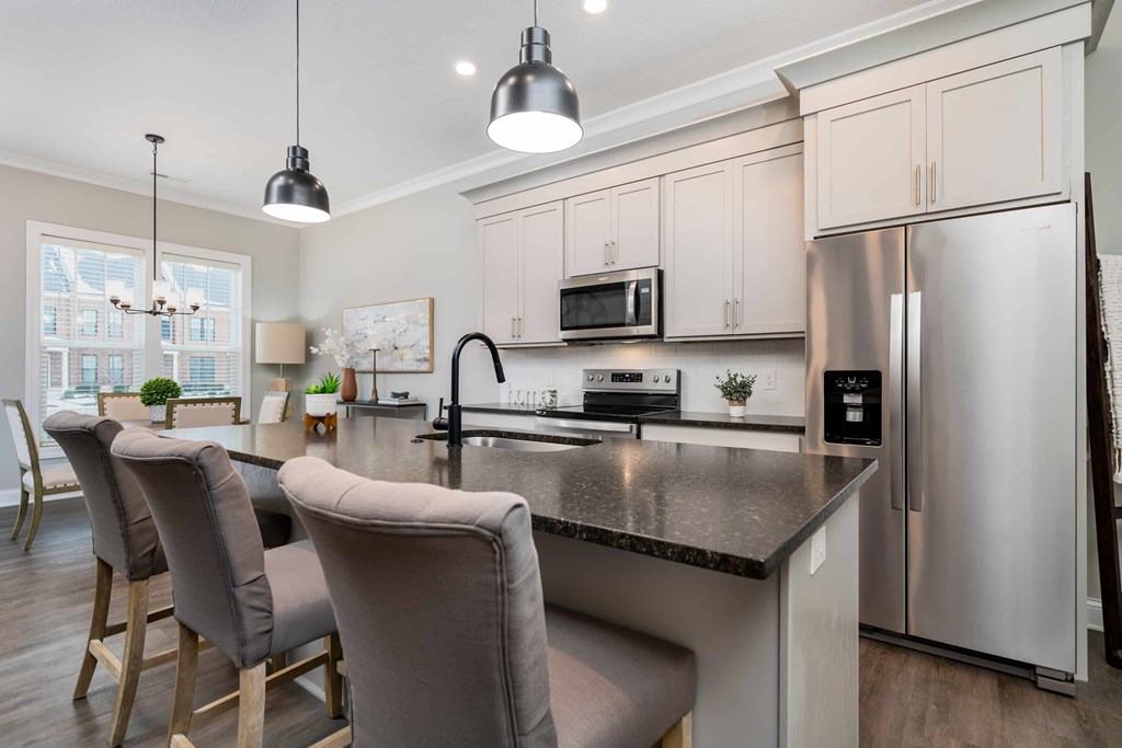 A modern kitchen with a large island and stainless steel appliances.
