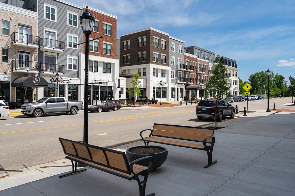 A city street with a bench and a lamp post.