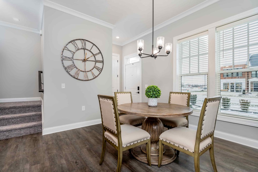 A dining room with a round table and chairs.