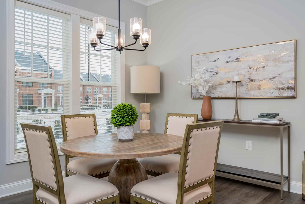A dining room with a round table and chairs.
