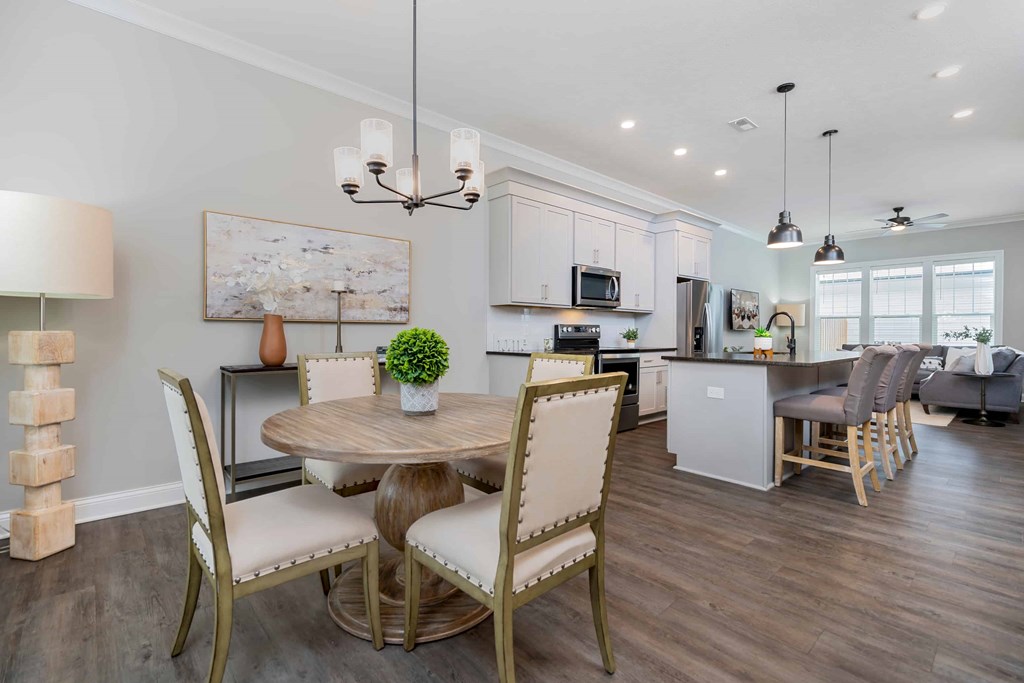 A modern dining room with a round table and chairs.