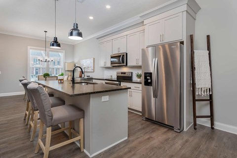 A modern kitchen with a large island and stainless steel appliances.