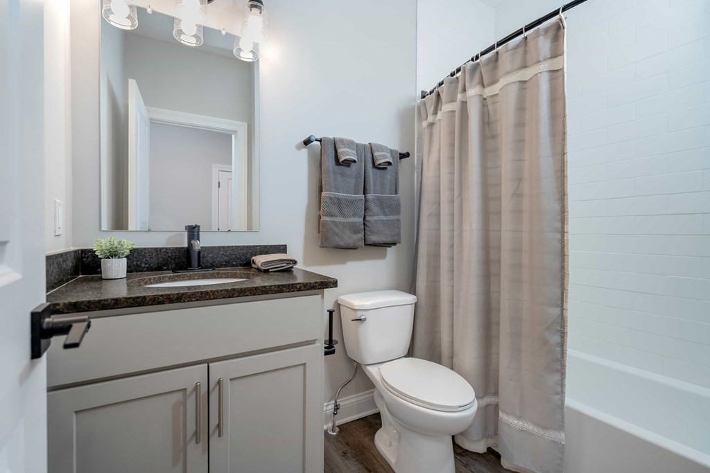 A bathroom with a toilet, sink, and shower.