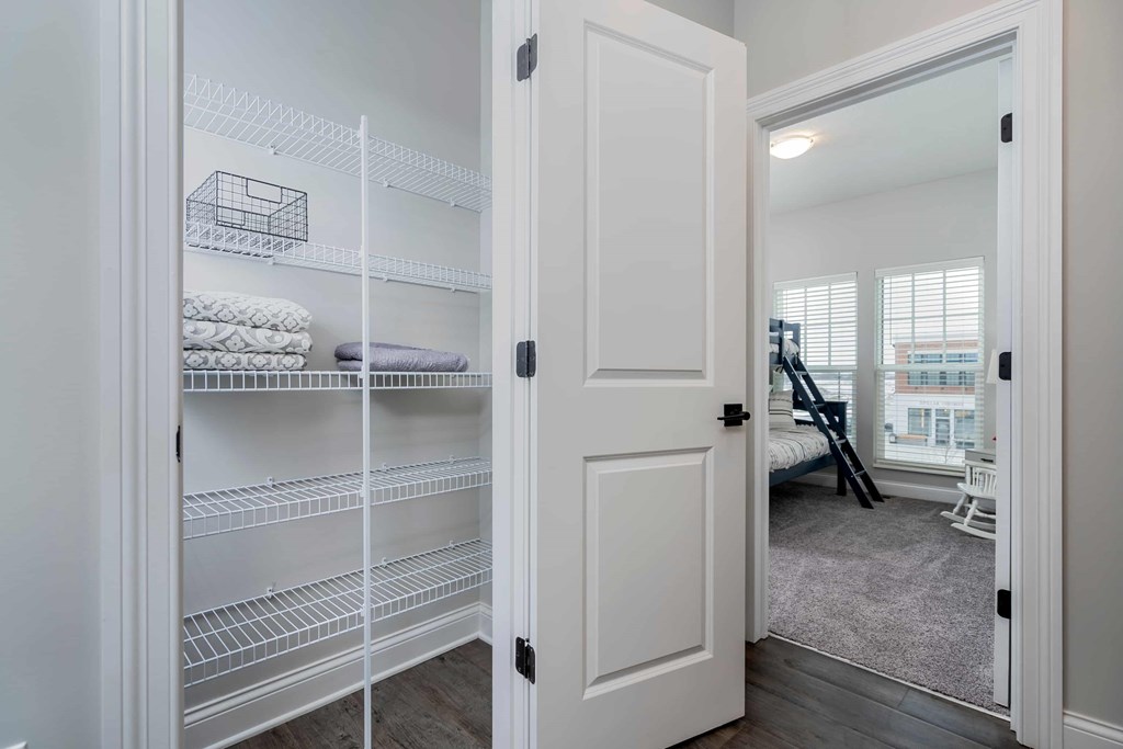 A white closet with shelves and towels.