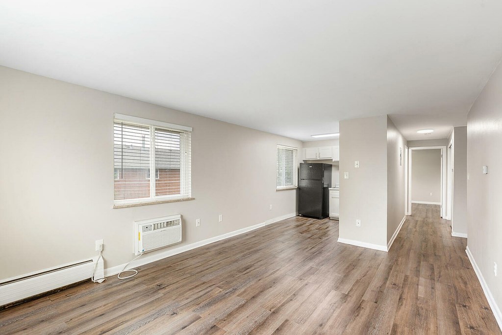 A room with wooden floors and a window with blinds.