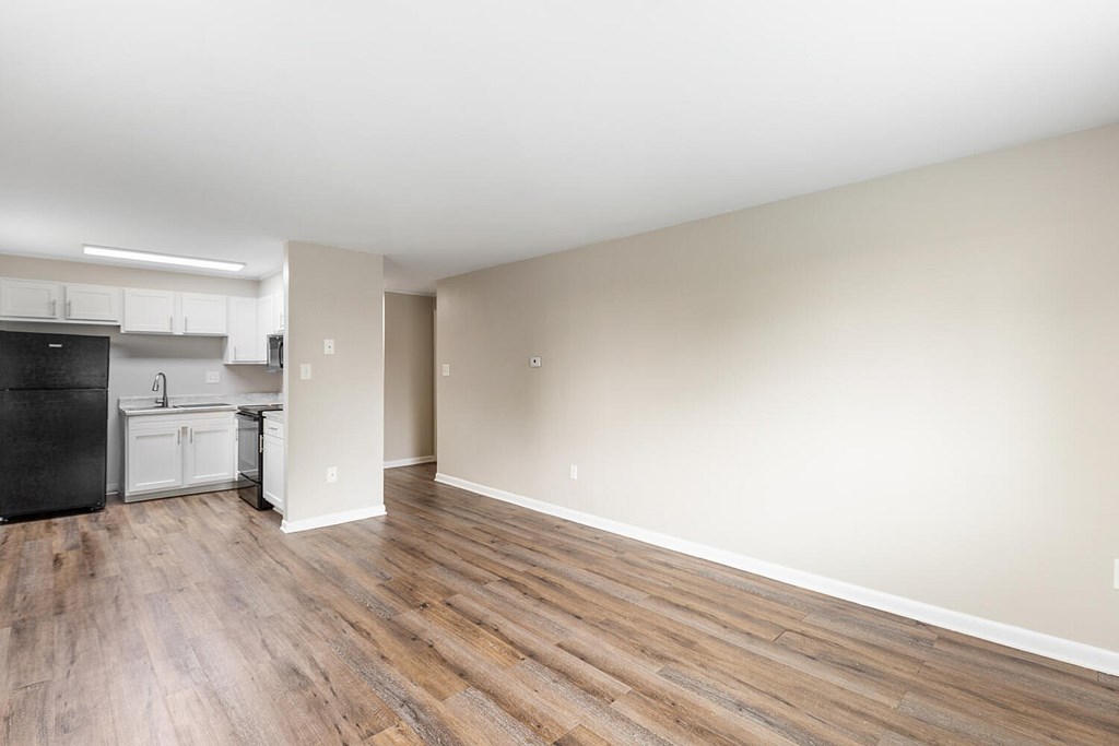 A kitchen with a black fridge and white cabinets.