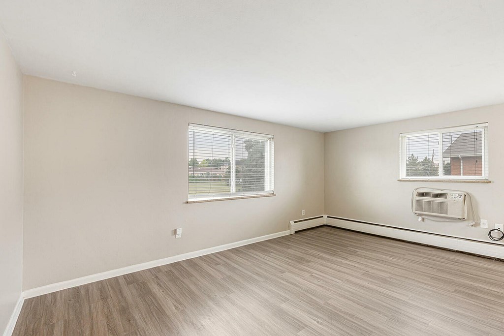 A room with a window and a wall-mounted air conditioner unit.