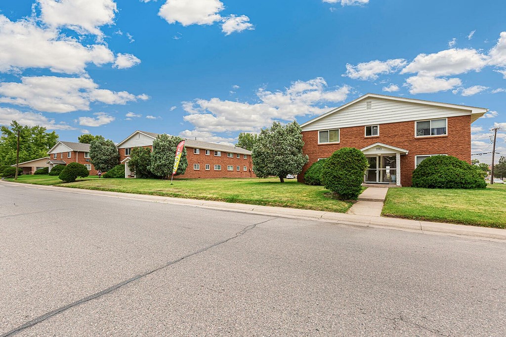 A red brick house with a white door and windows.