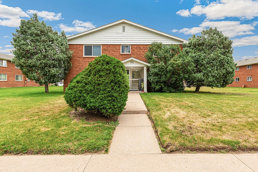 A red brick house with a white door and windows.