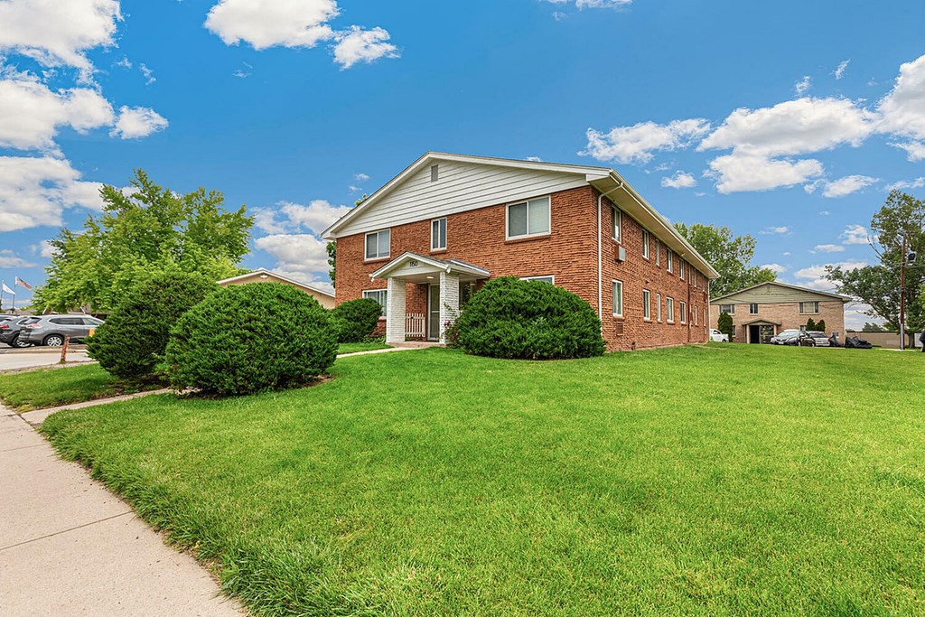 A red brick house with a white door and windows.
