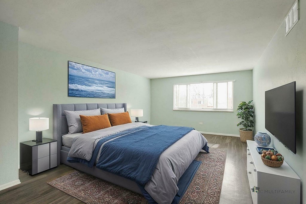 A bedroom with a large bed and a painting on the wall.