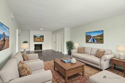 A living room with a grey couch, a coffee table, and a painting on the wall.