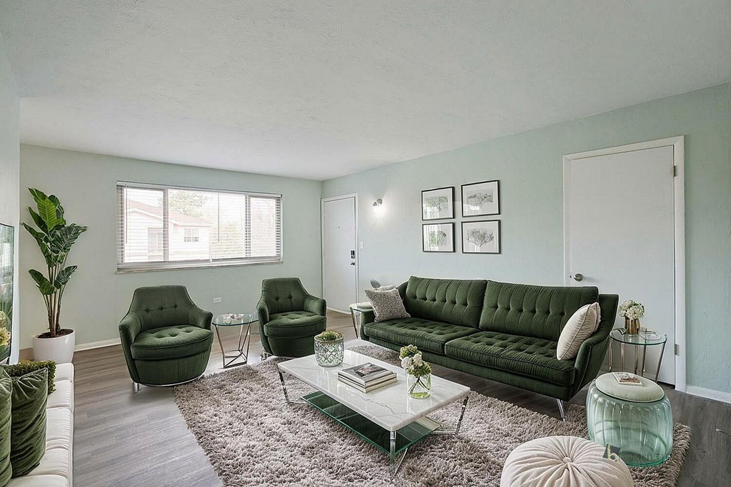 A living room with a green couch and matching chairs.