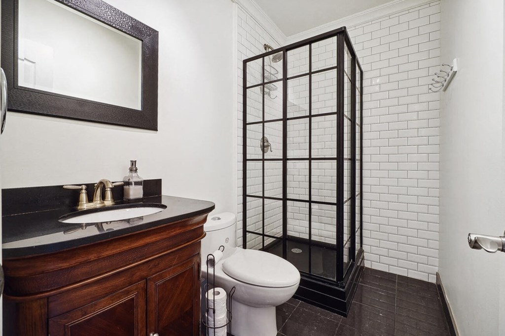 A bathroom with a toilet, sink, and shower.