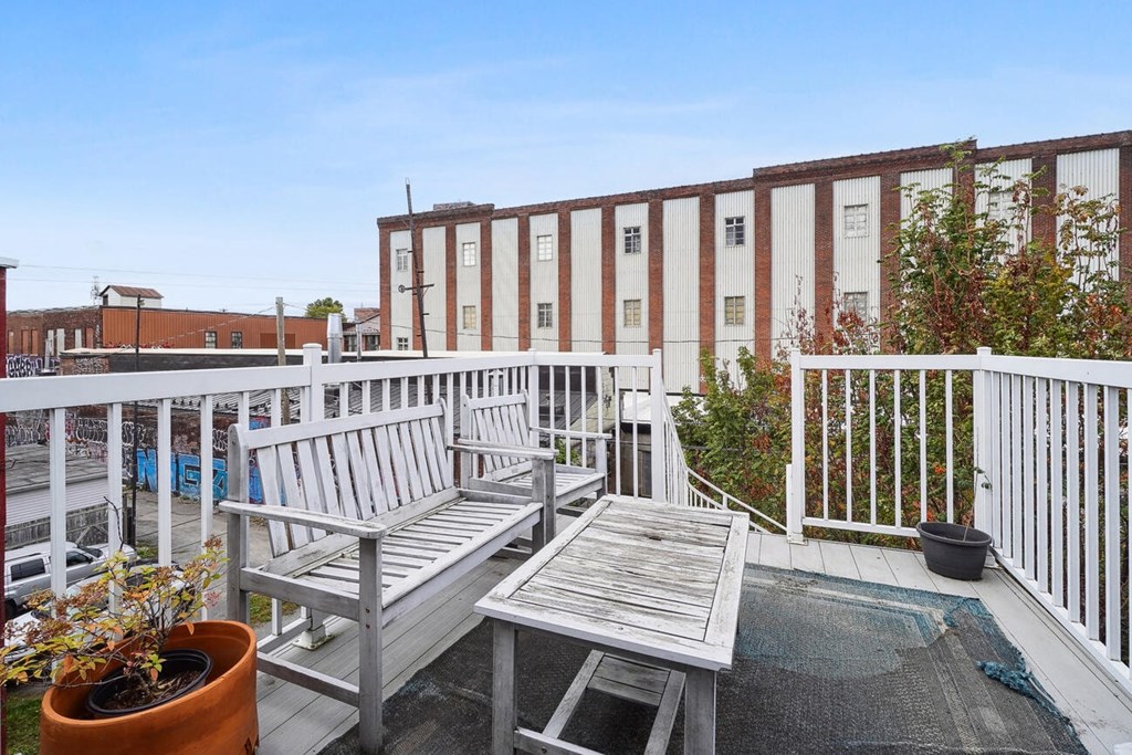 A balcony with a bench and table.