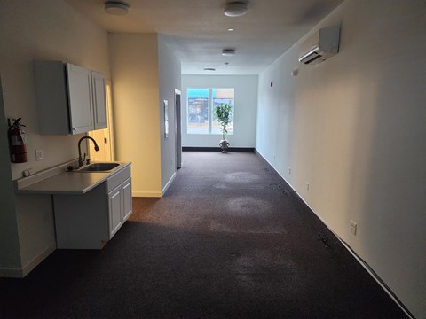 A long hallway with a kitchen area on the left.