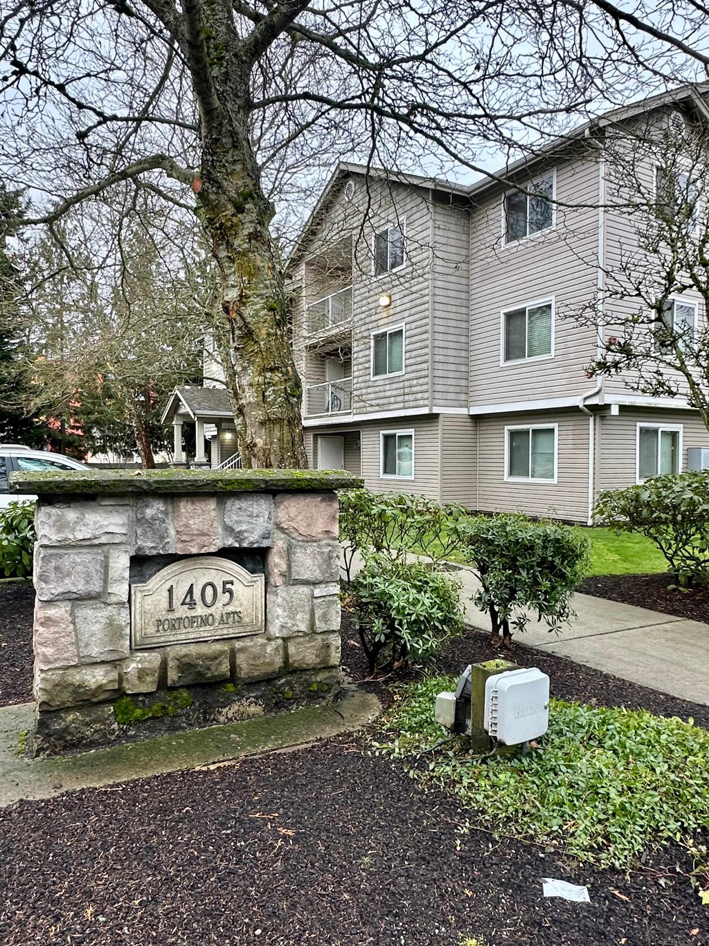 A stone wall with a plaque that reads 1405 Apartments.
