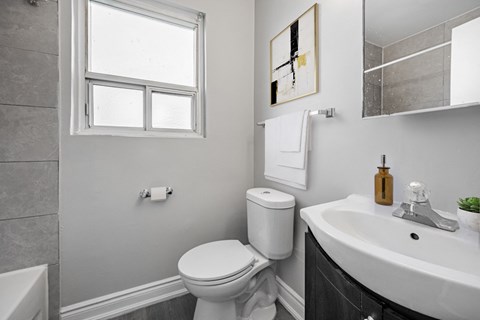 A white toilet sits next to a sink in a bathroom.