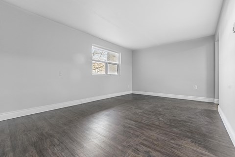 A room with wooden flooring and a window.