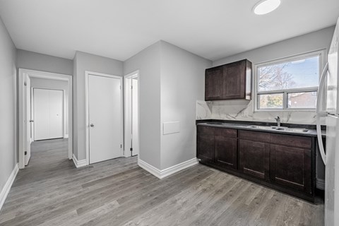 A bathroom with a sink, mirror, and wood flooring.