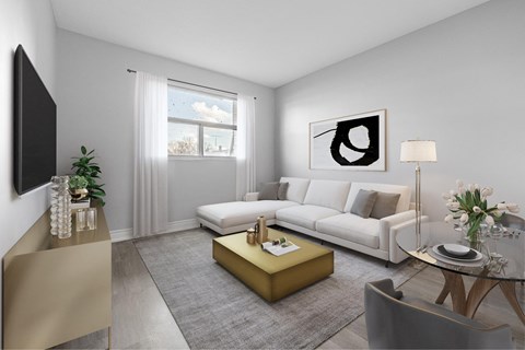 A modern living room with a white sofa, a coffee table, and a large abstract painting on the wall.