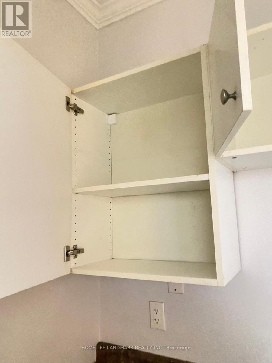 A white cabinet with an open drawer and a closed cabinet above it.