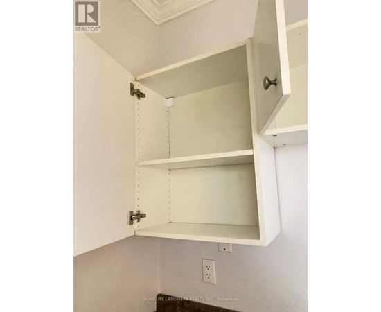 A white cabinet with an open drawer and a closed cabinet above it.