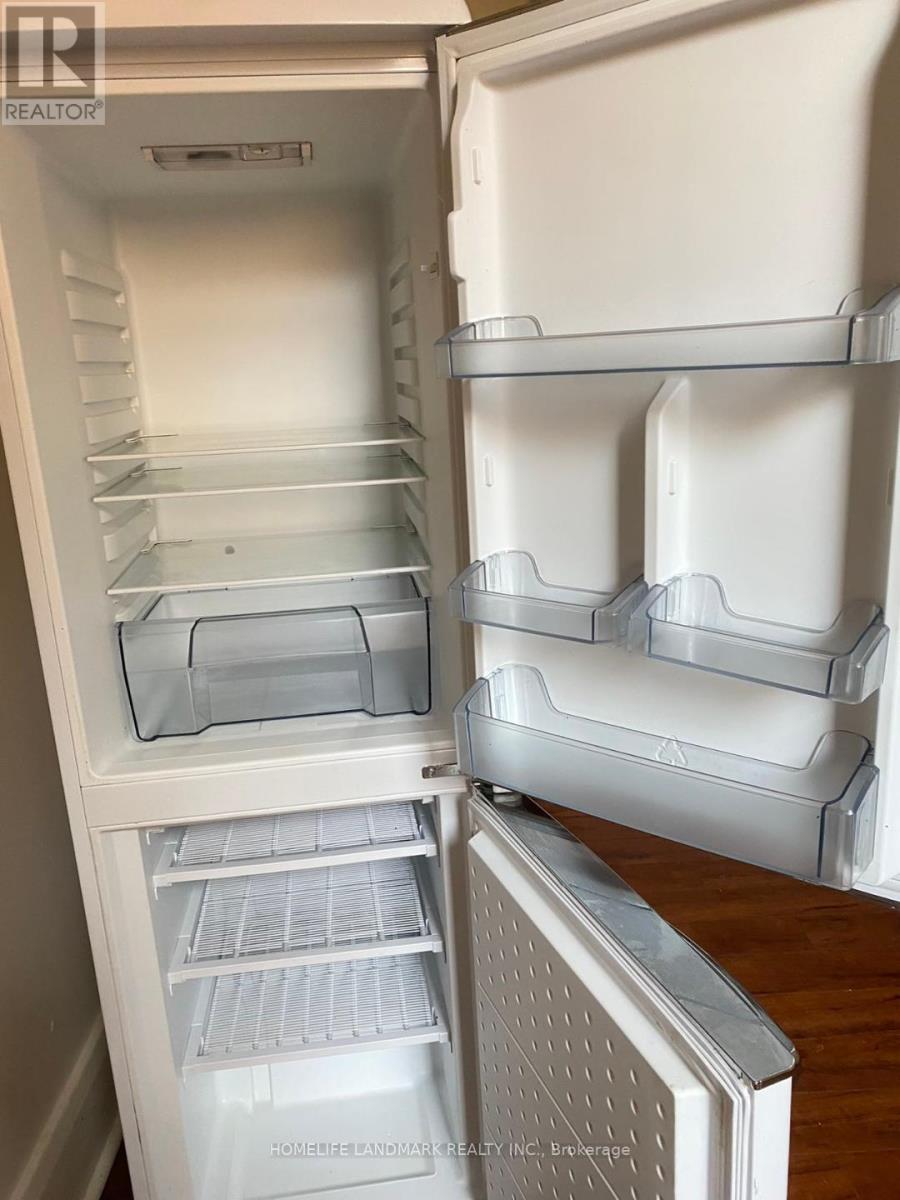 A white refrigerator with the door open and shelves inside.