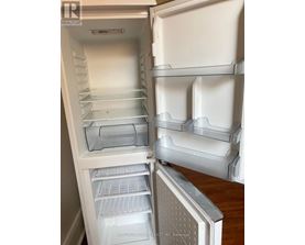 A white refrigerator with the door open and shelves inside.