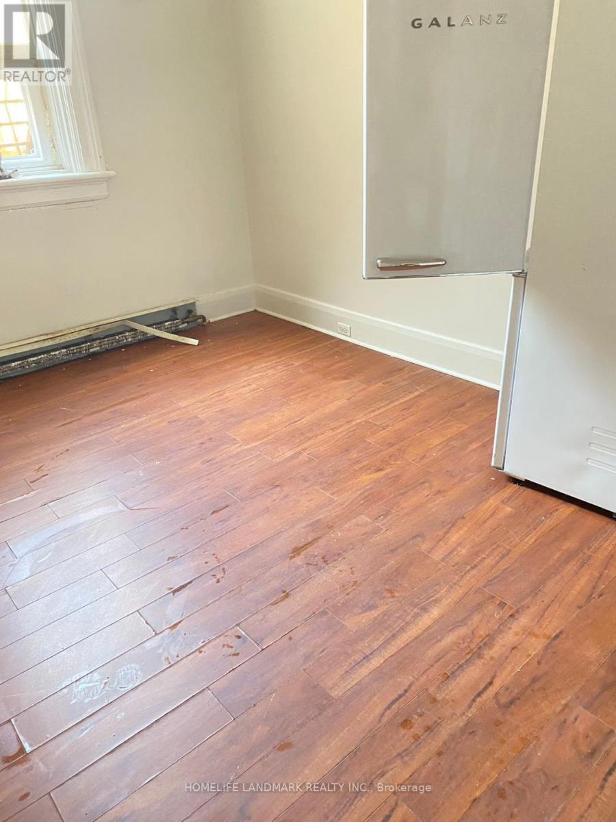 A room with wooden flooring and a white door.
