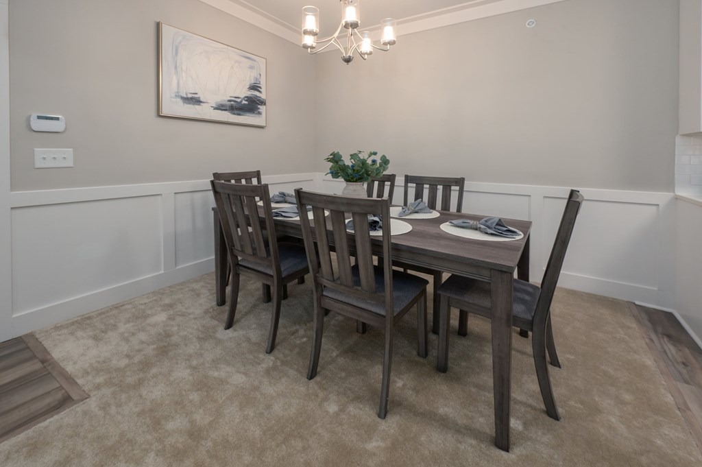 A dining room with a table and chairs.