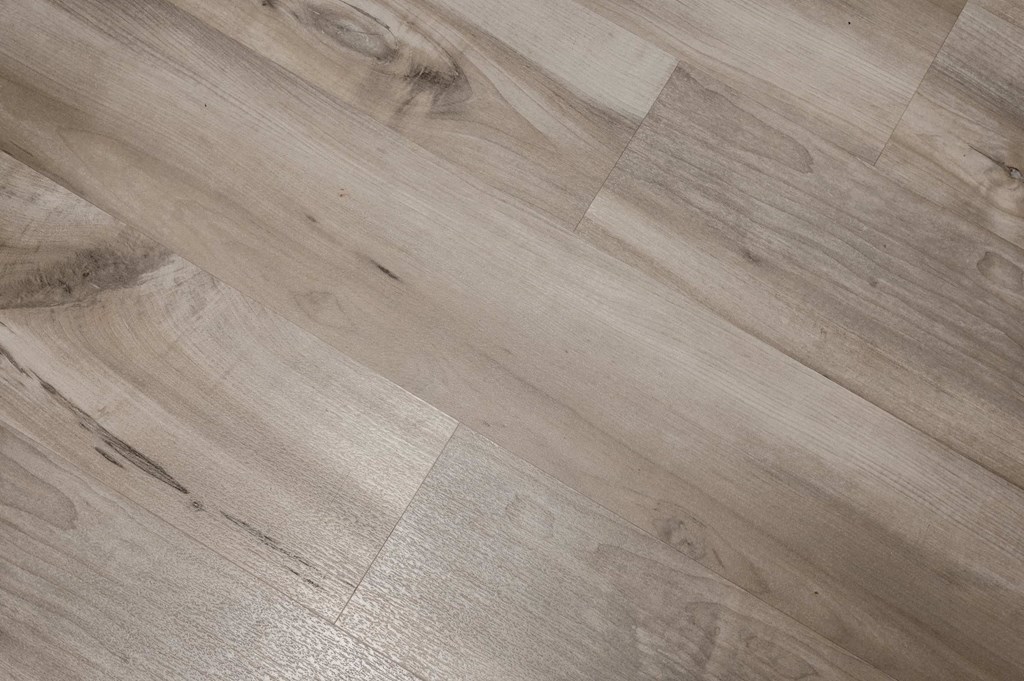 A close up of a wooden floor with a light brown hue and visible grain patterns.