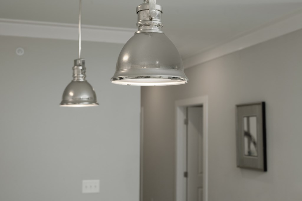 A silver pendant light hangs over a white door.