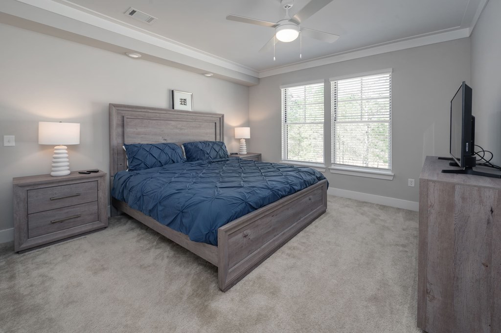 A bedroom with a bed, nightstands, and a television.