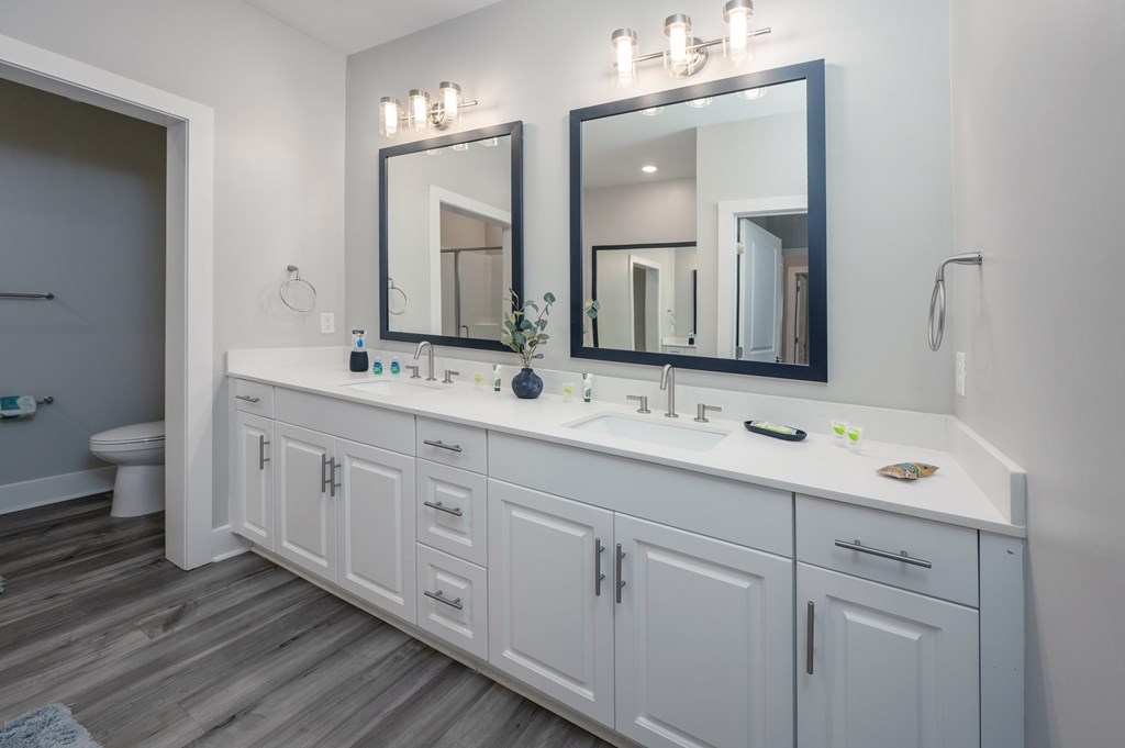 A bathroom with a white vanity and a large mirror above it.