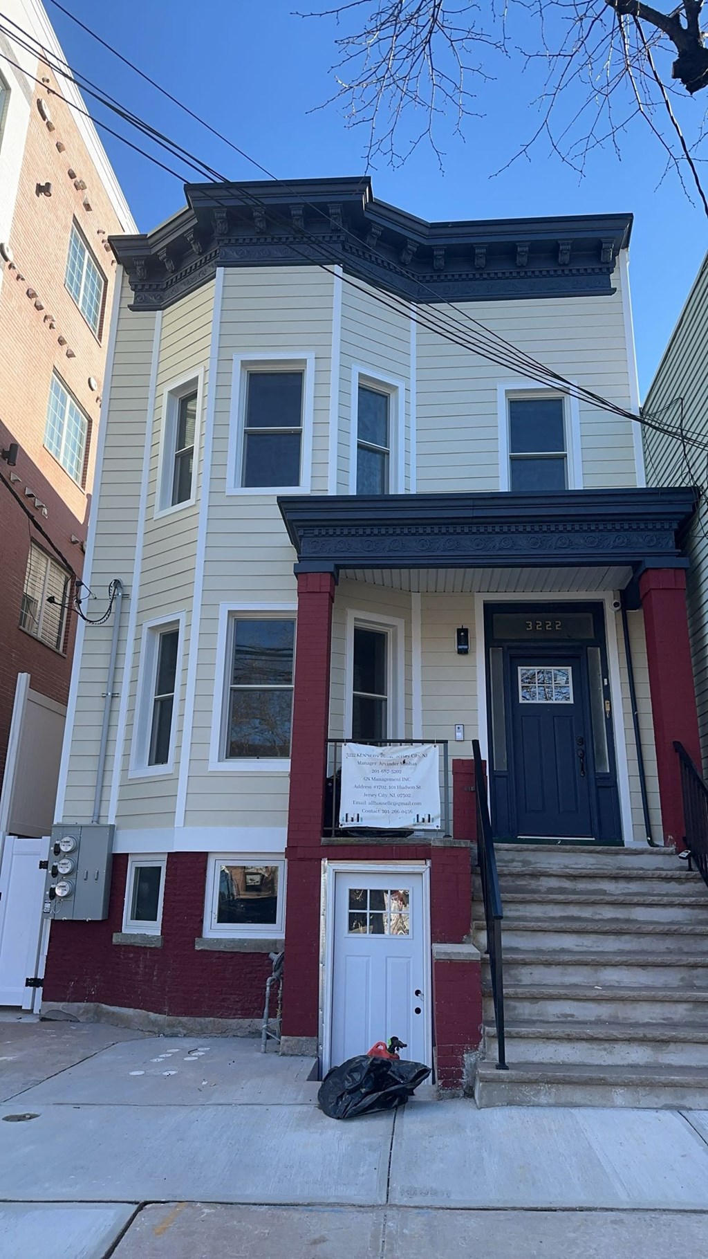 A two-story house with a red door and a white door.