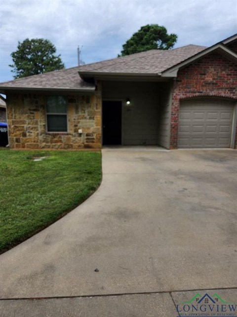 A brick house with a driveway in front.