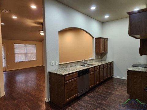 A kitchen with wooden cabinets and a granite countertop.