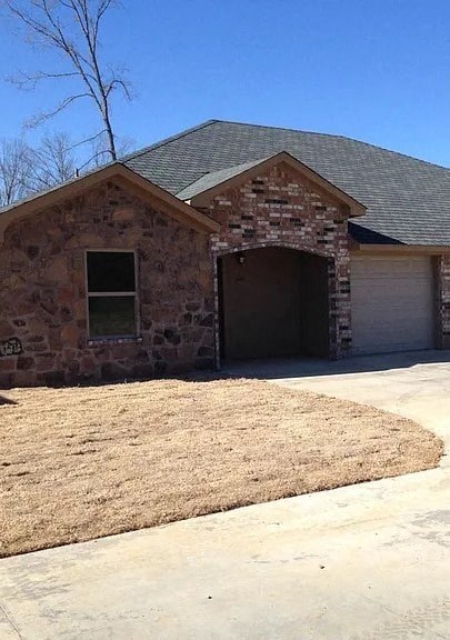 A house with a stone facade and a grey roof.