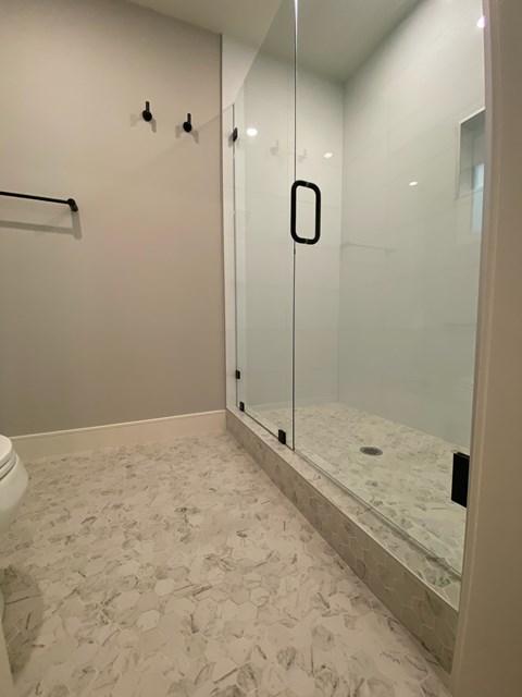 A white bathroom with a glass shower door.
